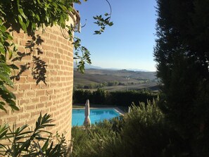 Una piscina al aire libre de temporada, sombrillas, tumbonas