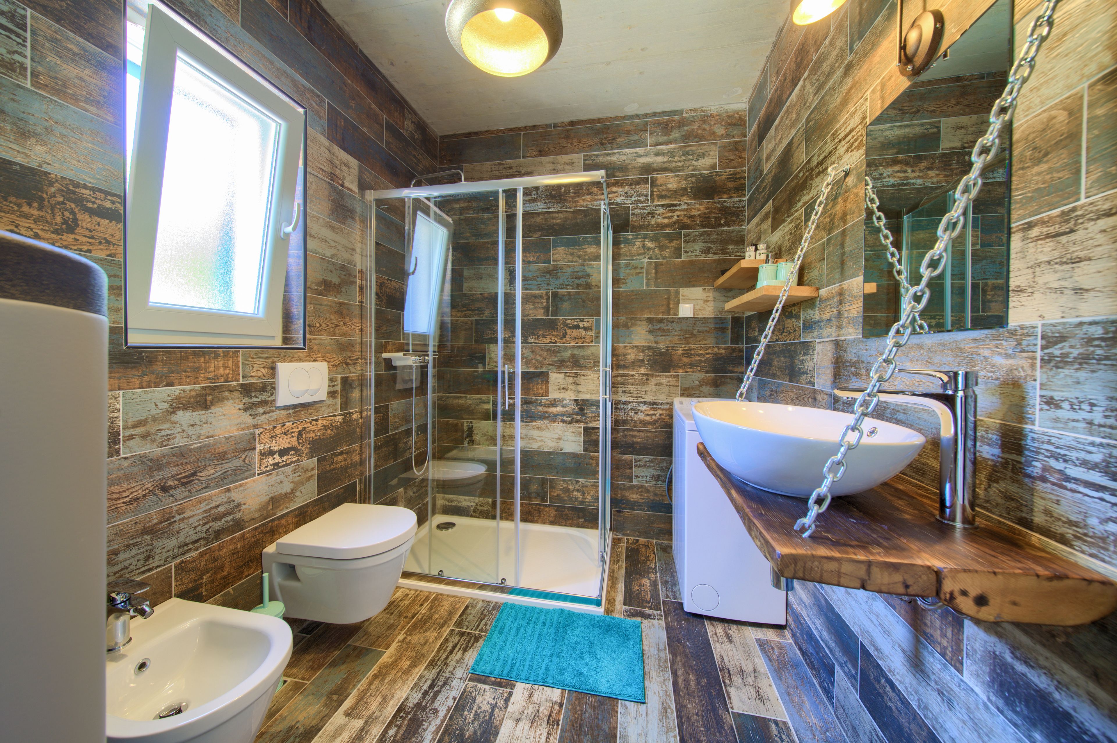 Une salle de bain moderne avec une douche à parois de verre, un lavabo blanc et un bidet.