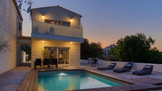 A two-story house with a swimming pool, outdoor seating, and a barbecue area. - Pax House 1 (Krk)