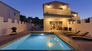 A swimming pool with lounge chairs and a barbecue grill. - Pax House 2 (Krk)
