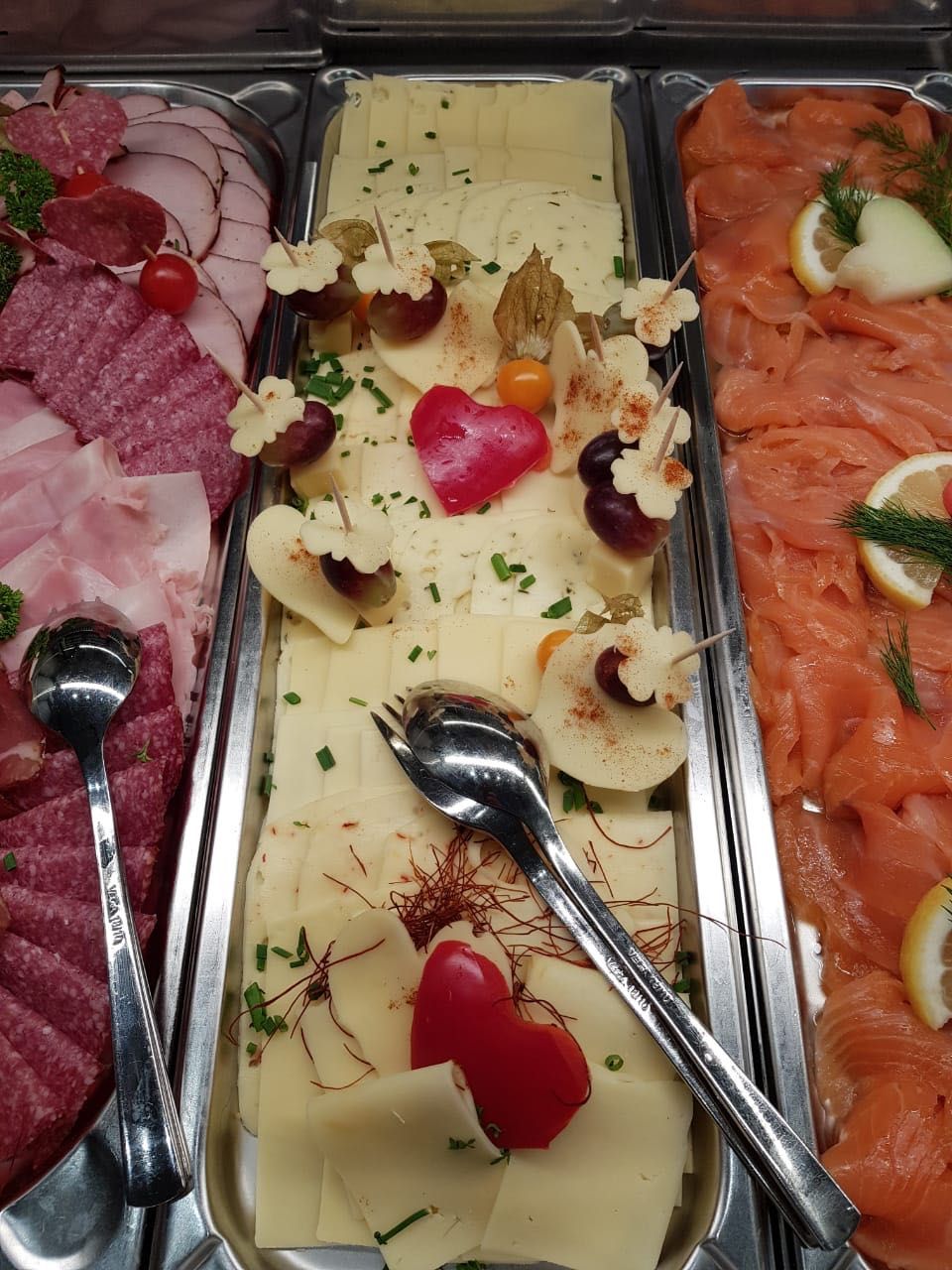 Un buffet proposant une variété de plats, notamment des viandes, des fromages et des accompagnements.