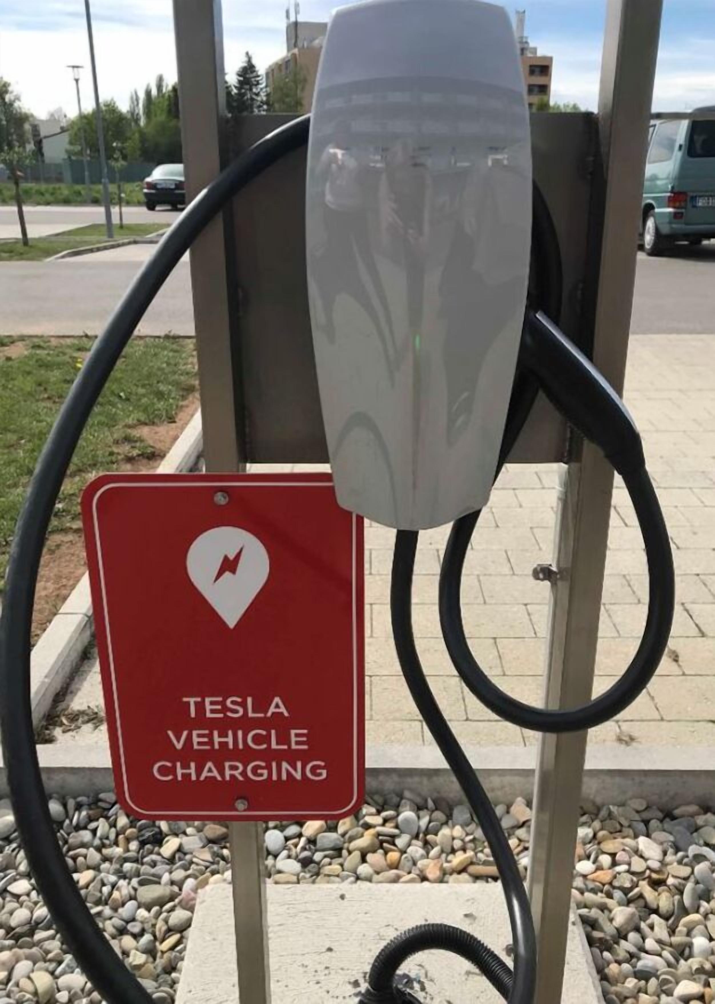 A Tesla vehicle charging station with a red sign indicating it is for Tesla vehicles.