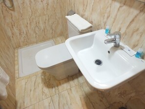 A bathroom with a toilet, sink, and shower.