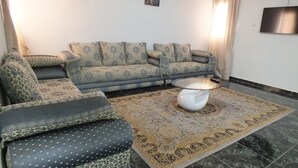 A living room with a sofa set, a coffee table, and a patterned rug.