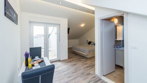 A modern apartment with a dining area, a bedroom with a bed and a view, and a bathroom with a sink and mirror. - Bovolini's Place (Dubrovnik)