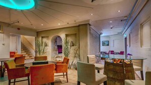 A modern interior with a dining area, a staircase, and a glass table with a barrel base. - Hotell Eikerapen Gjestegard (Aseral)