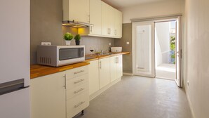 Una cocina compacta con microondas, pileta y alacenas.