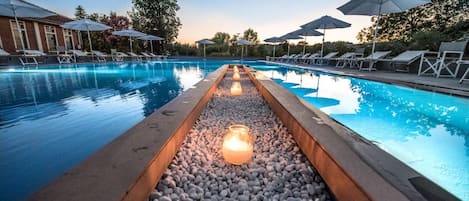 En säsongsöppen utomhuspool och solstolar