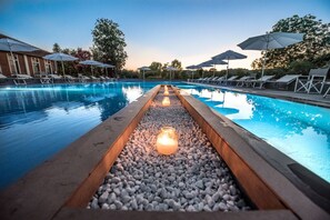 A swimming pool with lounge chairs and umbrellas, surrounded by trees and a building. - Locanda Ferro UNO Golf Città di Asti (Asti)