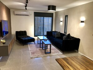 Departamento de diseñador, varias camas | Área de sala de estar | Televisión de pantalla plana de 42 pulgadas con canales por cable 