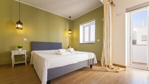 Una camera da letto con un letto, comodini, una finestra e vista sull'esterno.