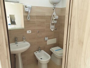 Chambre Quadruple Confort, vue ville | Salle de bain | Douche, douche à « effet pluie », sèche-cheveux, bidet