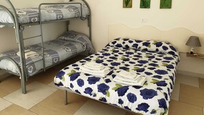 A bunk bed with a patterned bedspread and a single bed with a floral bedspread. - B&B Casa Terry (Marcianise)