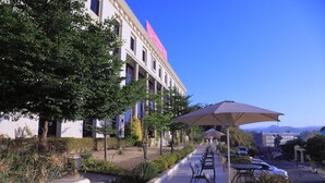 A hotel with outdoor seating and a large umbrella. - Haile Resort Gondar (Gondar)