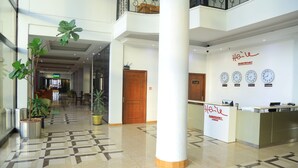 A hotel lobby with a reception desk, a check-in counter, and a wall with clocks. - Haile Resort Gondar (Gondar)