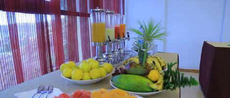 A breakfast buffet with various fruits and juices.