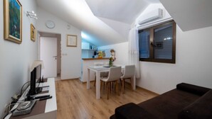 A compact living space with a dining area, a kitchenette, and a small seating area.