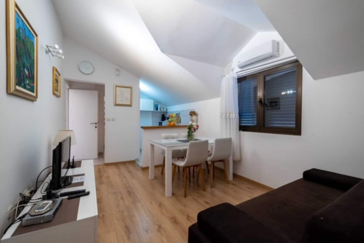 A compact living space with a dining area, a kitchenette, and a small seating area.