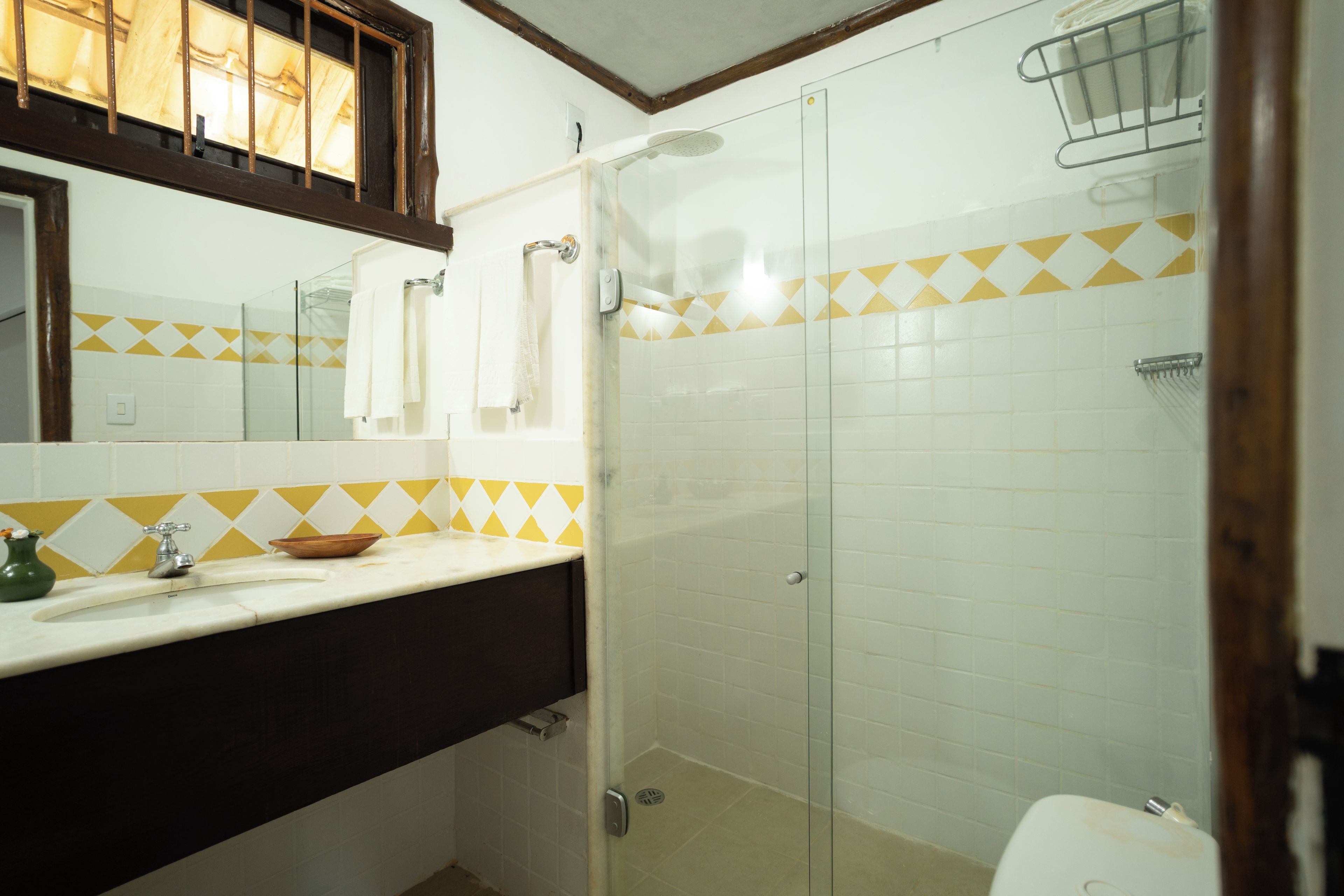 Un baño con ducha, lavamanos y espejo.
