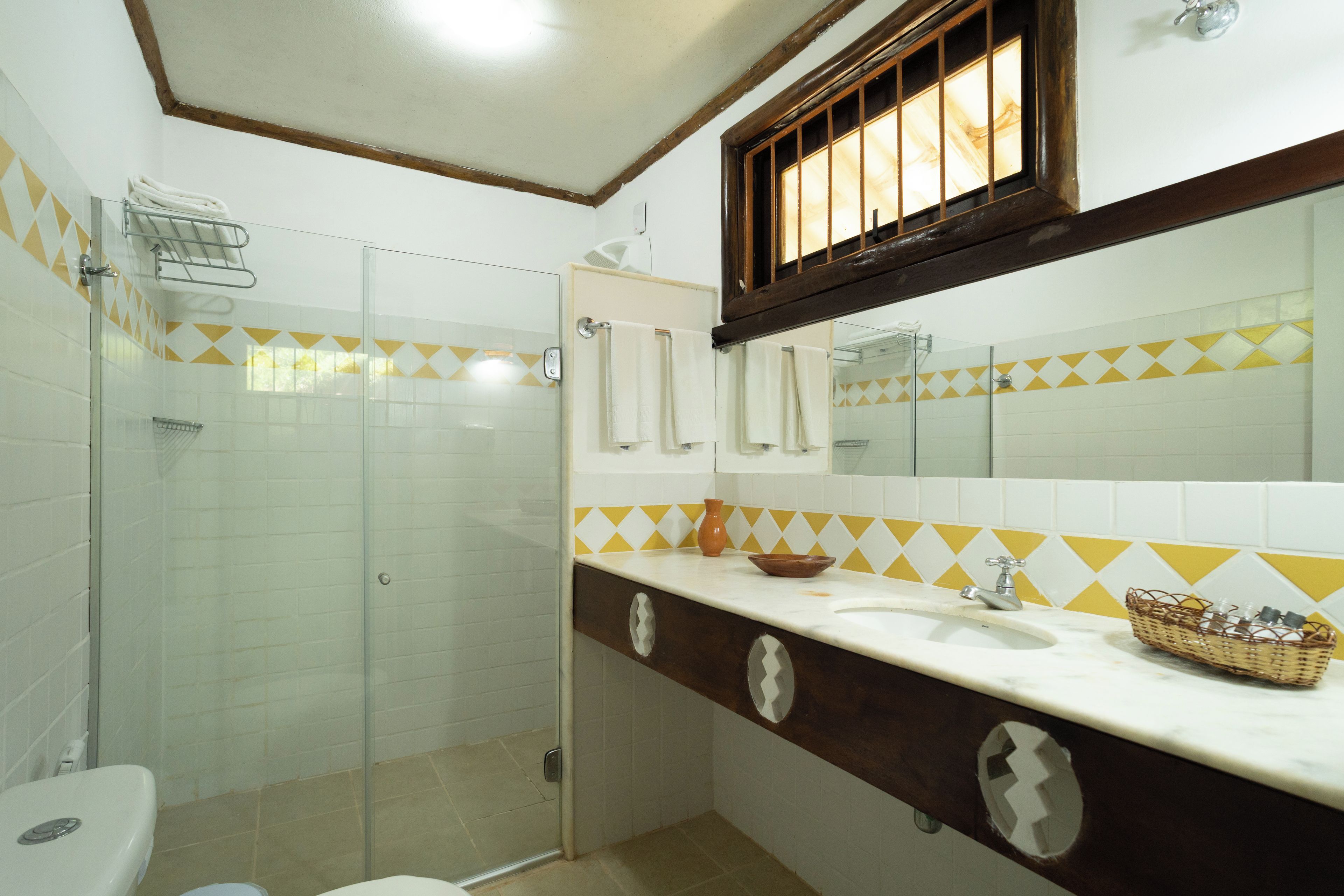 Une salle de bain avec douche, toilettes et lavabo.