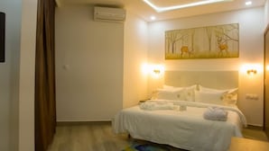 Una habitación de hotel con cama, un cuadro en la pared y una lámpara en el techo.