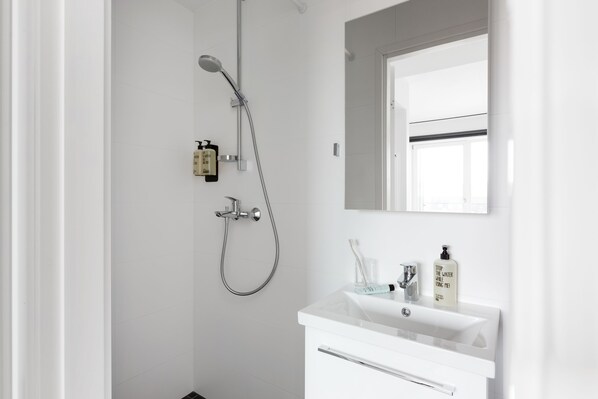 A modern bathroom with a shower, a sink, and a mirror. - Bob W Tallinn Telliskivi (Tallinn)
