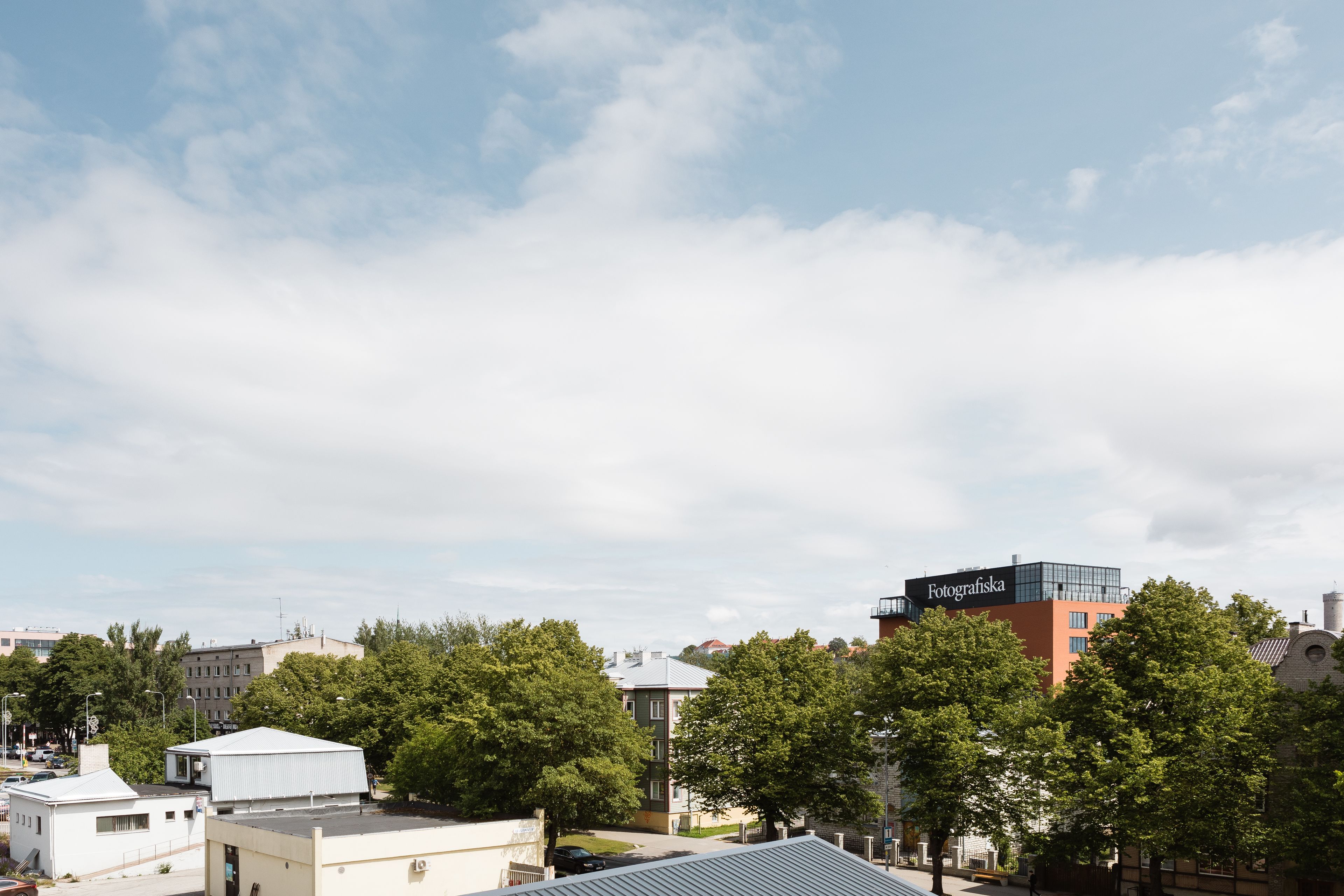 A cityscape with buildings, trees, and a clear sky.