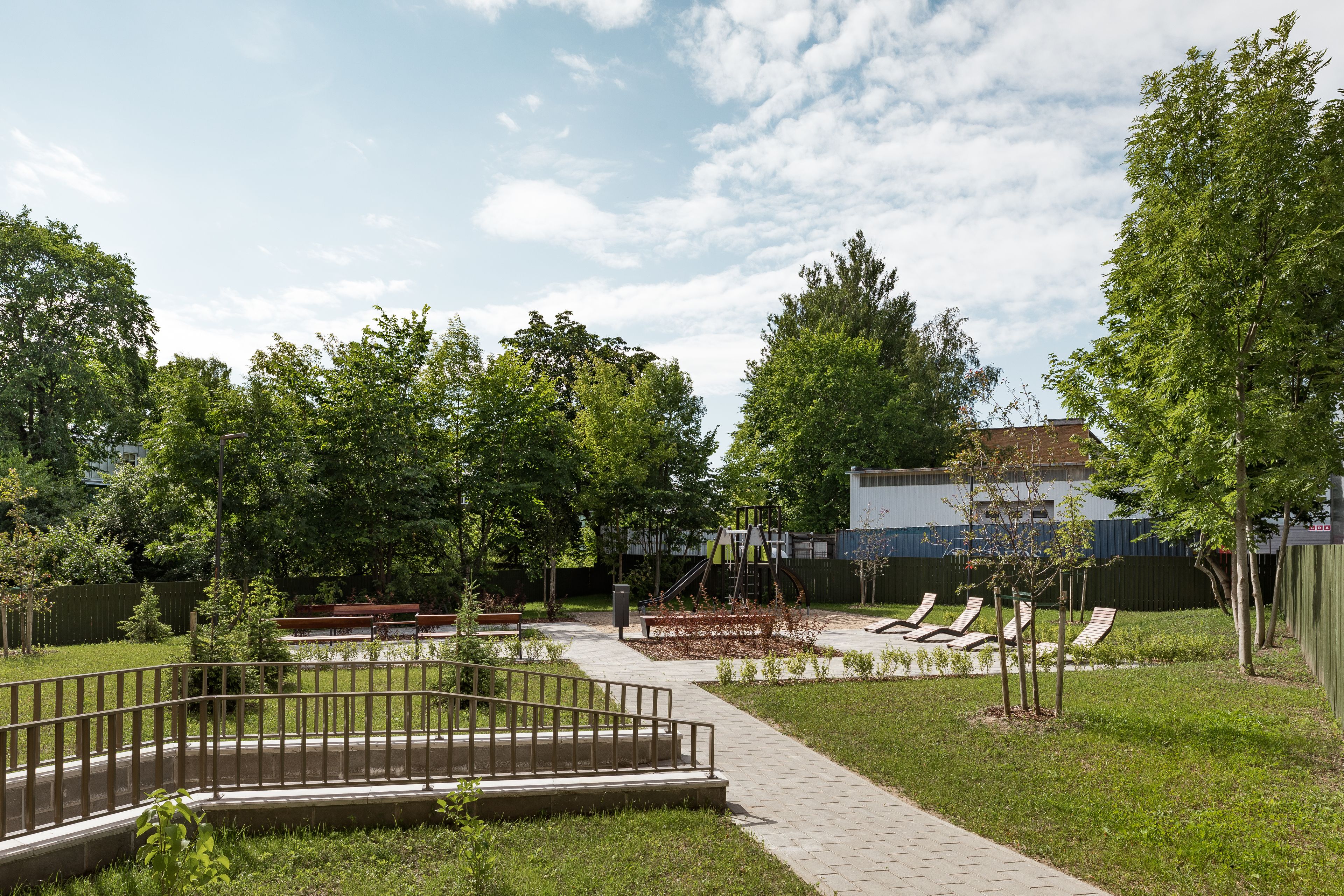 A park with a playground, walking paths, and seating areas.