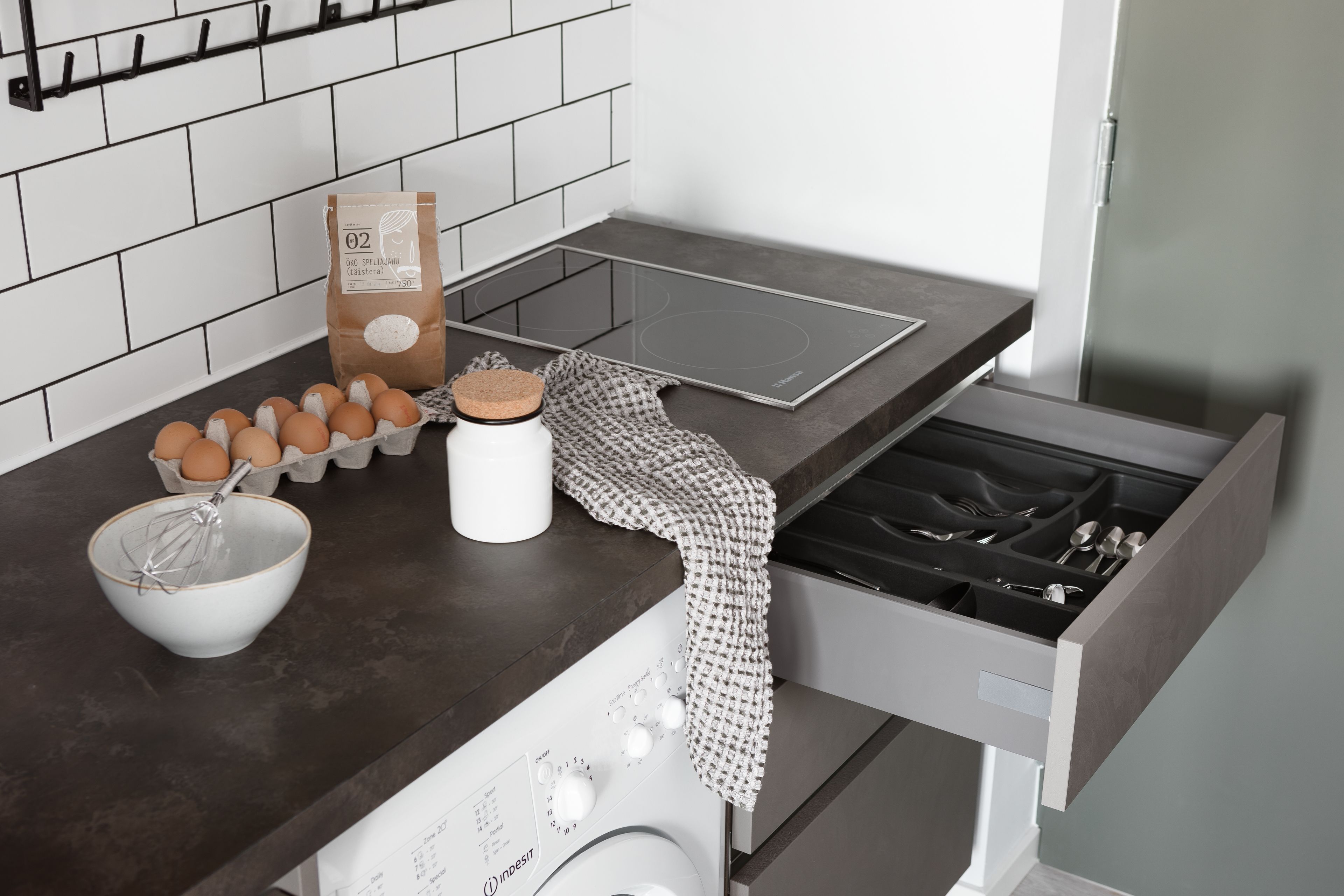 Een keuken met een inbouwoven, een koffiezetapparaat, een waterkoker en een set eieren.