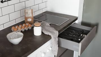Een keuken met een inbouwoven, een koffiezetapparaat, een waterkoker en een set eieren.