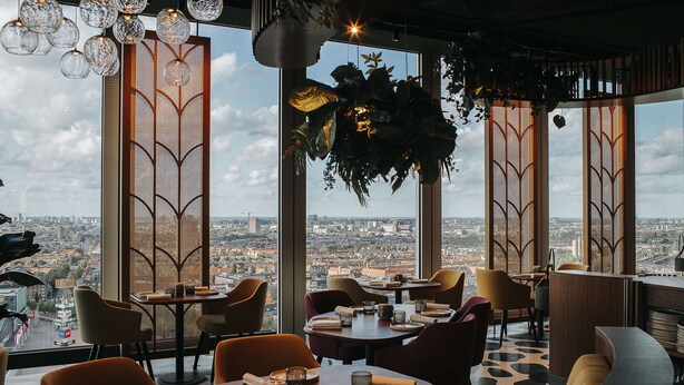 A restaurant with a city view, modern decor, and a variety of seating options. - nhow Amsterdam RAI (Amsterdam)