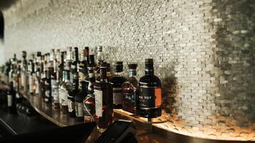 A bar with a hexagonal patterned wall and various bottles of liquor.