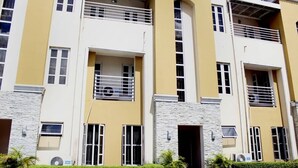 A multi-story residential building with balconies, large windows, and a stone facade. - Aden 360 Apartments By Intra (Lagos)