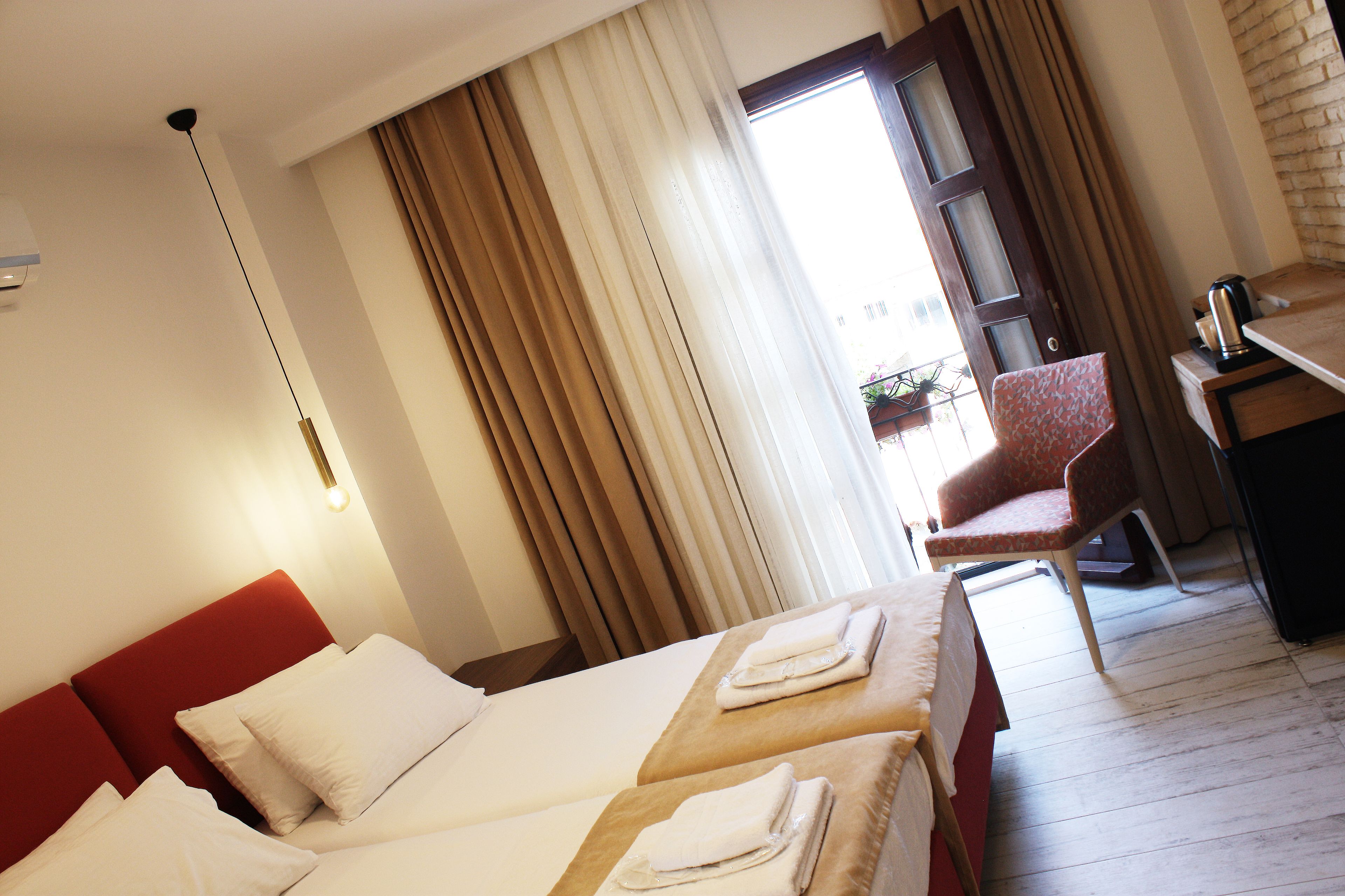 Habitación de hotel con dos camas, un escritorio y una silla.