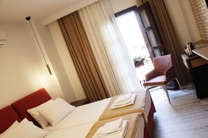 Habitación de hotel con dos camas, un escritorio y una silla.