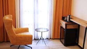 A room with a yellow armchair, a small round table, a coffee machine, and a wooden desk. - Pintura Urla Butik Otel & Sanat Galerisi (Urla)