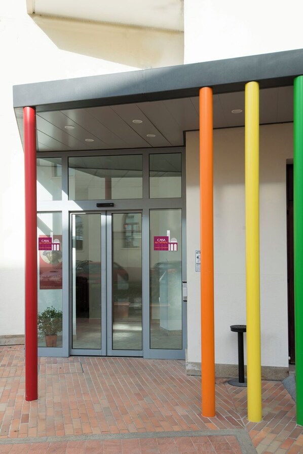 A building entrance with a glass door and a covered area. - Casa al Carmine (Padova)