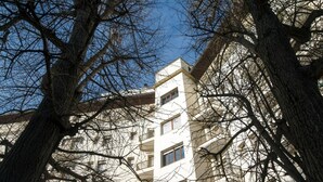 A multi-story building with balconies, surrounded by leafless trees. - Casa al Carmine (Padova)
