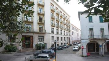 Un edificio de varios pisos con una entrada a nivel de calle que dice 'PENSIONATO PIAGGI'.