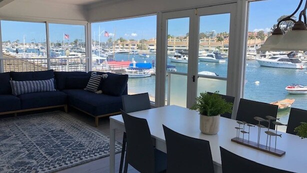 Un salon moderne doté d’une grande fenêtre donnant sur une marina.