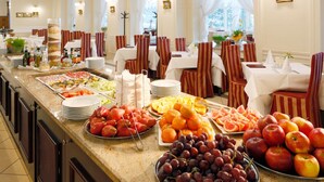Een buffet met verschillende soorten fruit en groenten, zoals druiven, appels en sinaasappels.