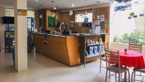 A reception area with a counter, chairs, and a table. - Hotel Venturim (Venda Nova Do Imigrante)