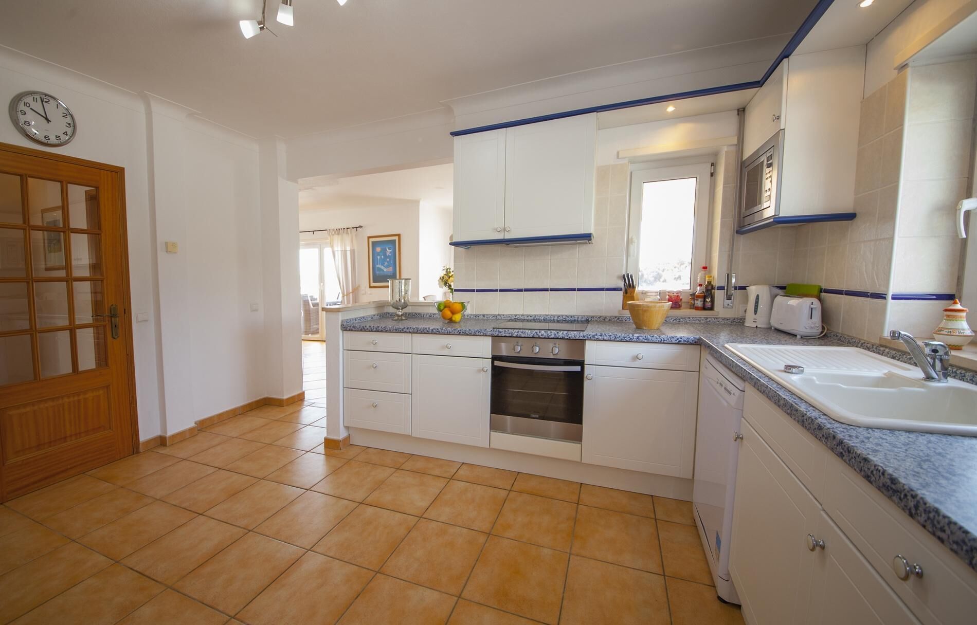 A modern kitchen with white cabinets, a built-in oven, and a granite countertop.