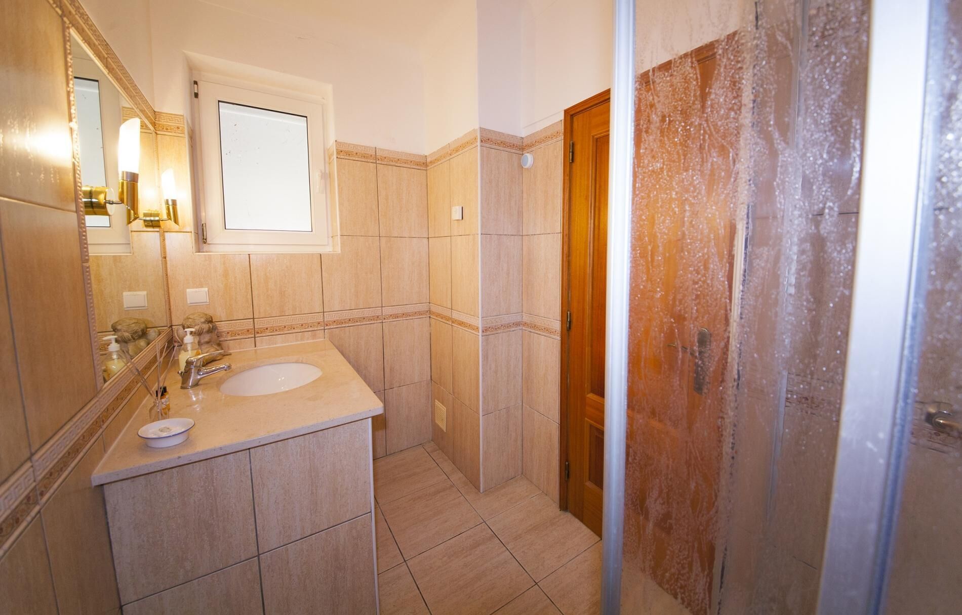 Ein Badezimmer mit Waschbecken, Spiegel und Dusche.