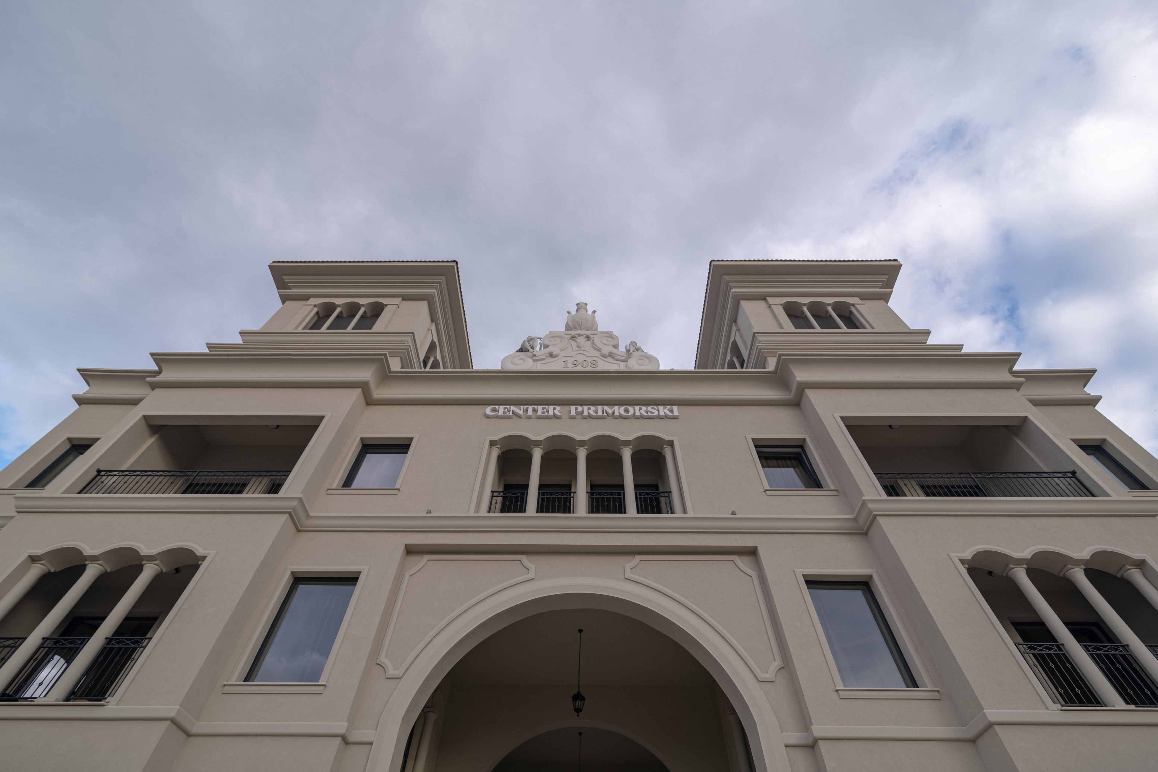 A building with the sign "CENTER PRIMORSKI" and a date "1908" on the facade.