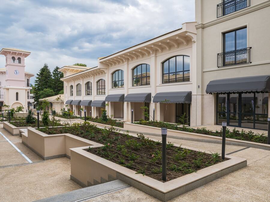 Une rangée de bâtiments d’hôtel dotés de grandes fenêtres et d’une cour intérieure agrémentée de jardinières.
