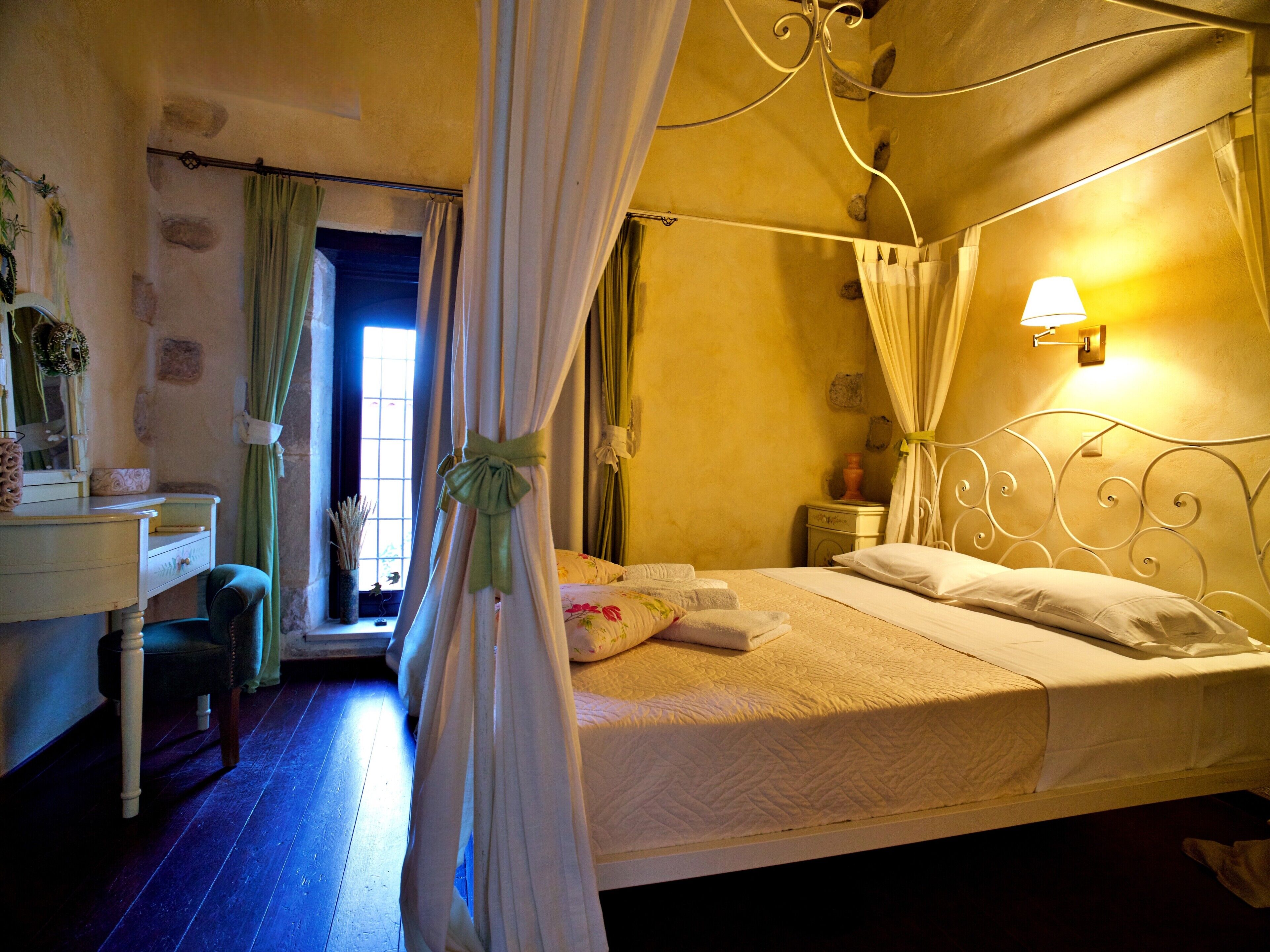 Une chambre à coucher avec un lit, une table de chevet, une lampe et une fenêtre avec des rideaux.