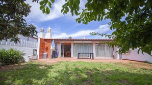 A house with a tiled roof, a patio with a table and chairs, and a garden area. - D10 - Ferragudo Townhouse by DreamAlgarve (Lagoa)
