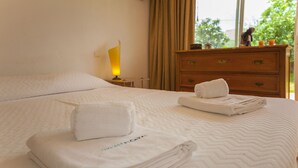 A neatly made bed with folded towels and a bedside lamp. - D10 - Ferragudo Townhouse by DreamAlgarve (Lagoa)