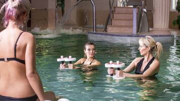 Una piscina techada, sillones reclinables de piscina